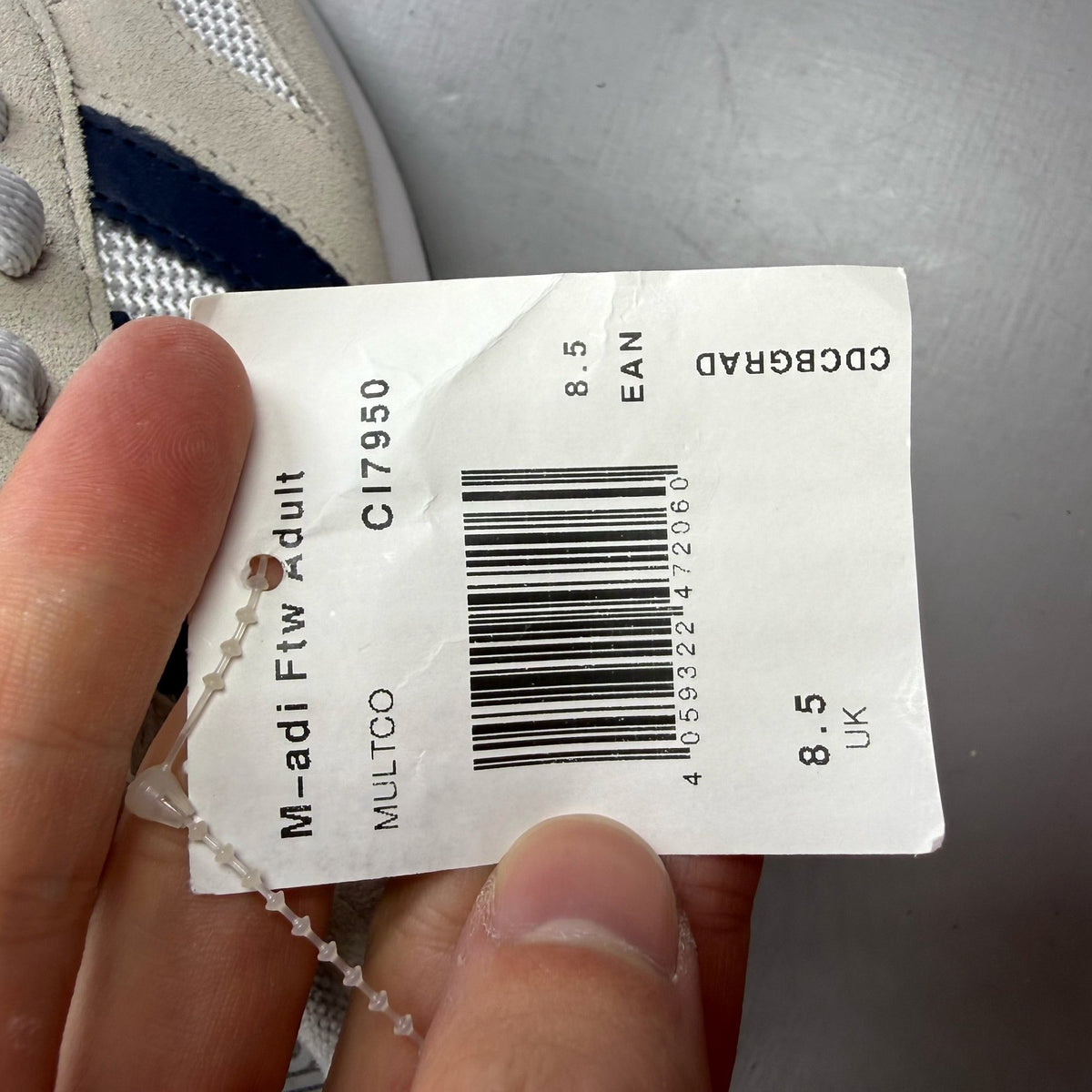 Adidas white LA Trainer sneakers with navy accents and classic three-stripe logo.
