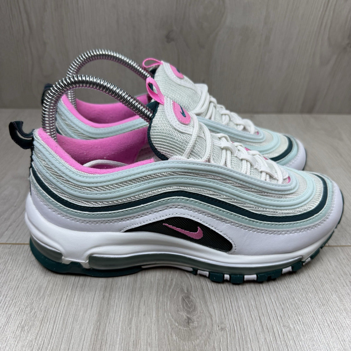 Nike Air Max 97 white trainers with teal accents and reflective detailing.