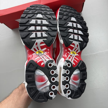 Nike Air Max Plus TN white trainers with university red and grey accents, featuring signature logo.