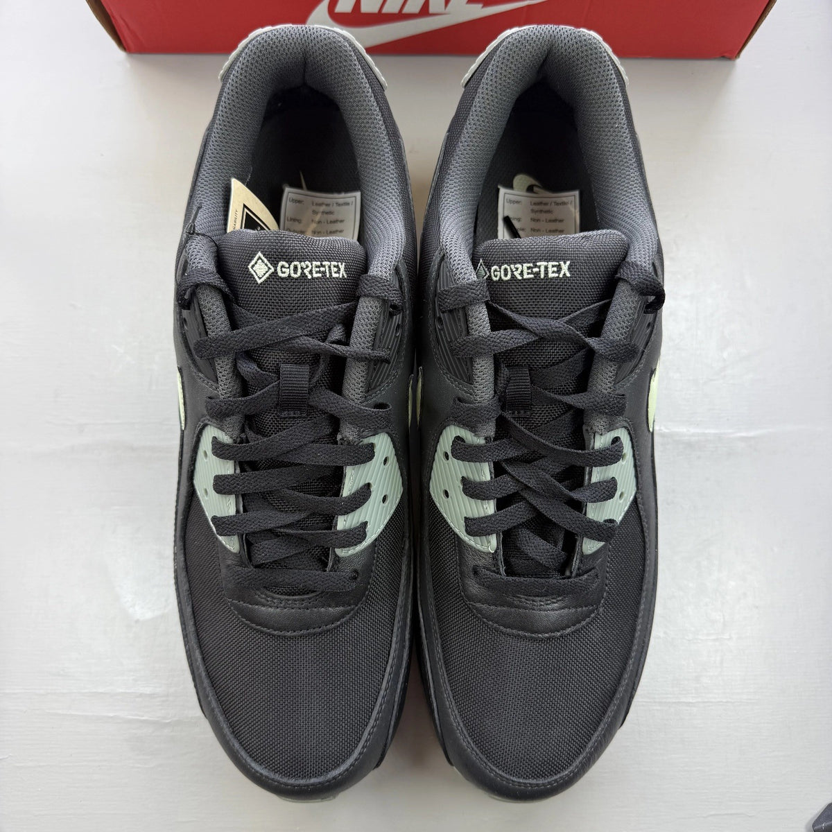 Nike Air Max 90 black trainers with Gore-Tex material and honeydew accents.