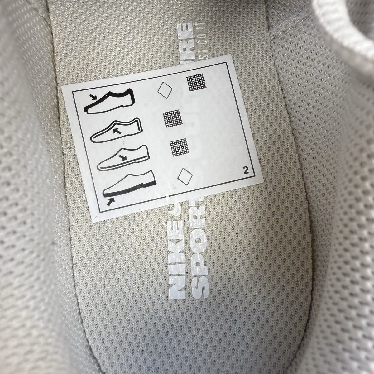 Nike Air Max trainers beige with pink accents and logo detail on the side.