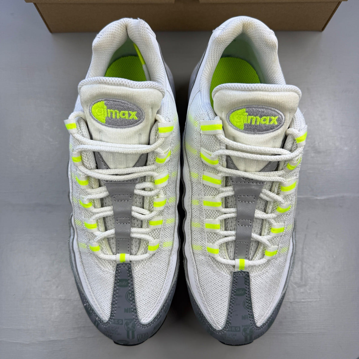 Nike trainers white with neon grey volt accents and retro logo details.