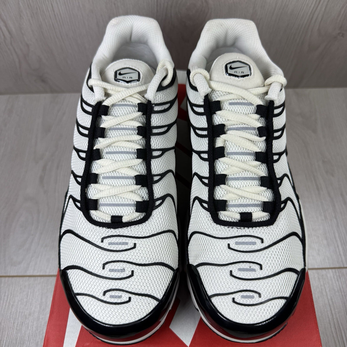Nike Air Max Plus TN ESS trainers white with black accents and signature swoosh logo.