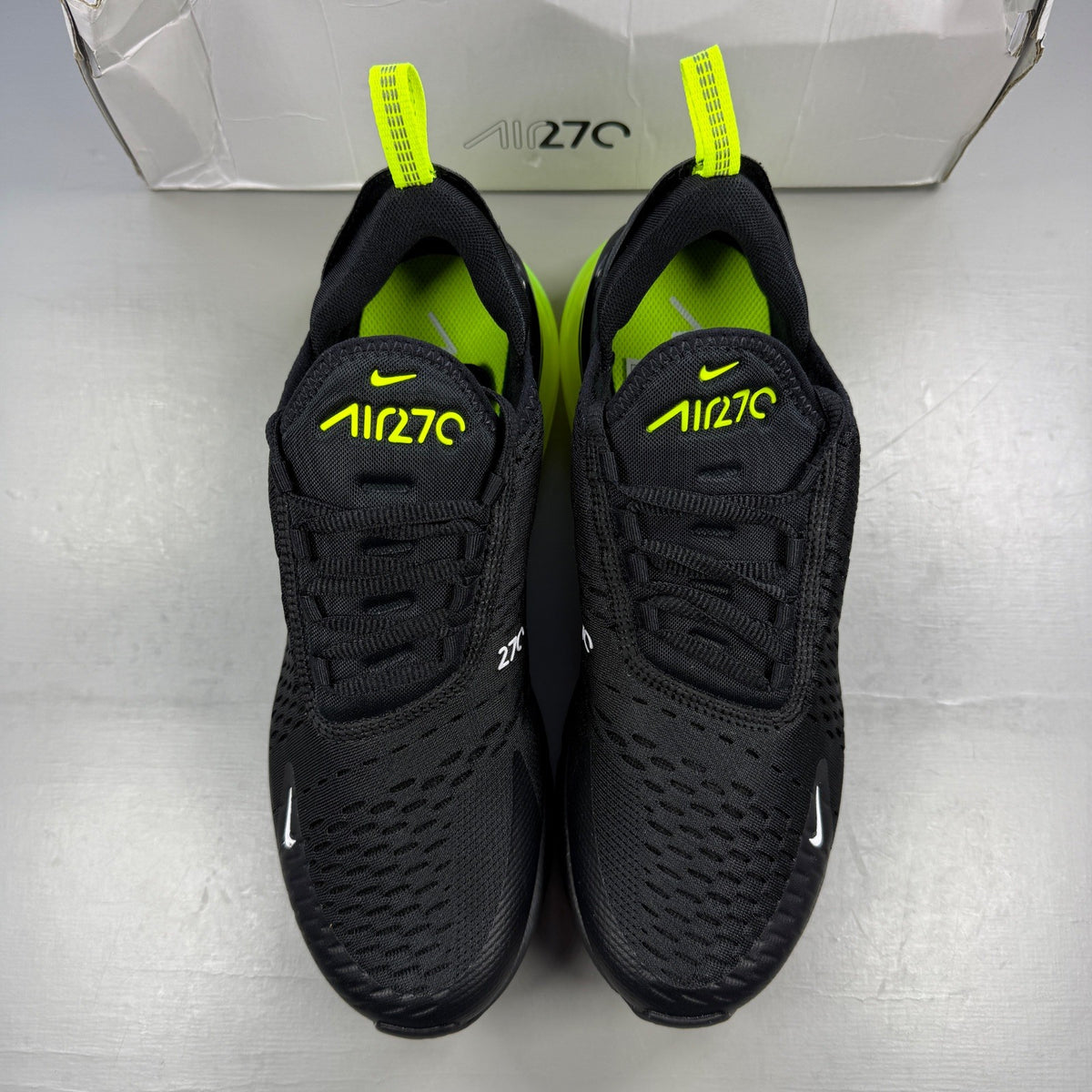 Nike running shoes black with volt neon accents and Air Max cushioning.