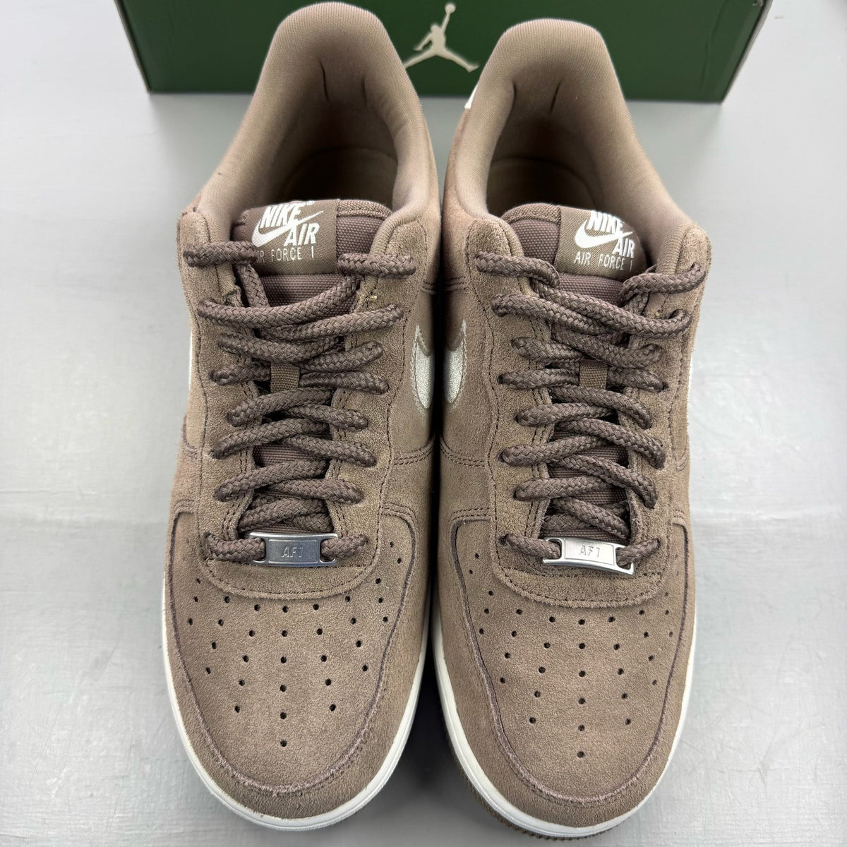 Nike brown trainers with leather upper and signature swoosh logo.