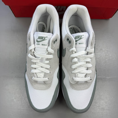 Nike trainers white with grey accents and green detailing, featuring iconic swoosh logo.