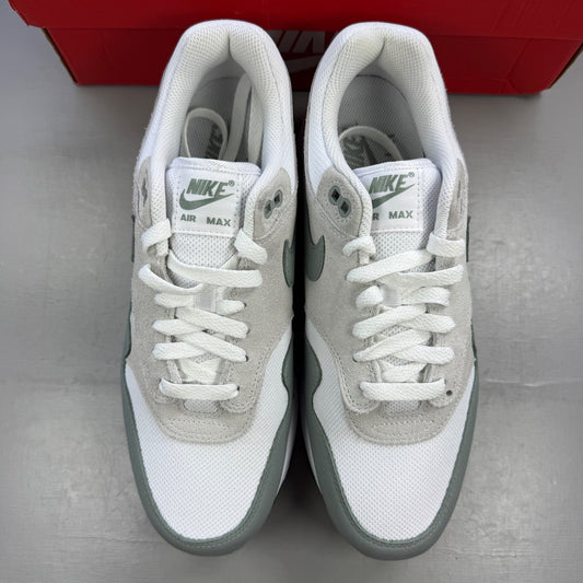 Nike trainers white with grey accents and green detailing, featuring iconic swoosh logo.