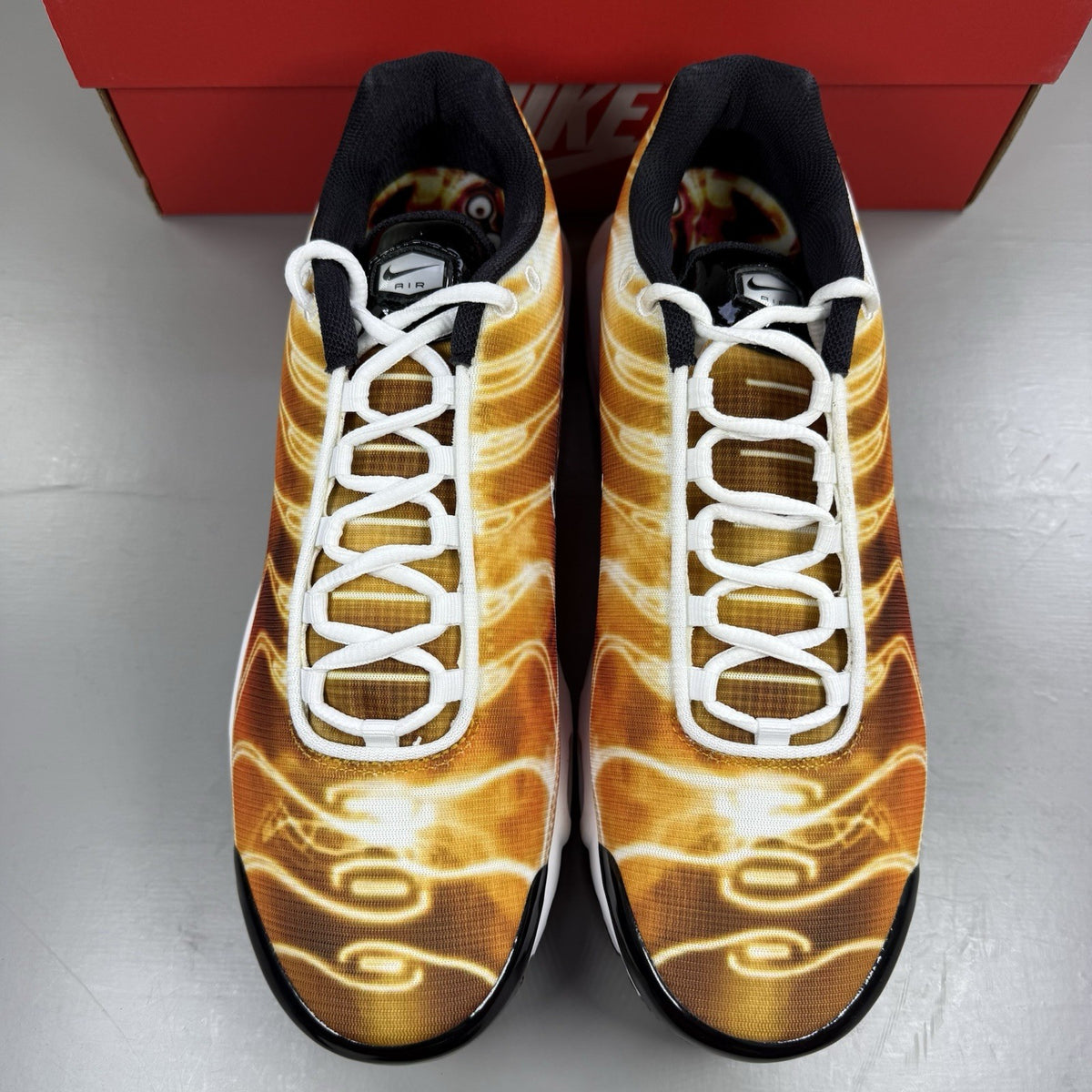 Nike Air Max Plus TN trainers in light photography orange with distinctive wavy design.