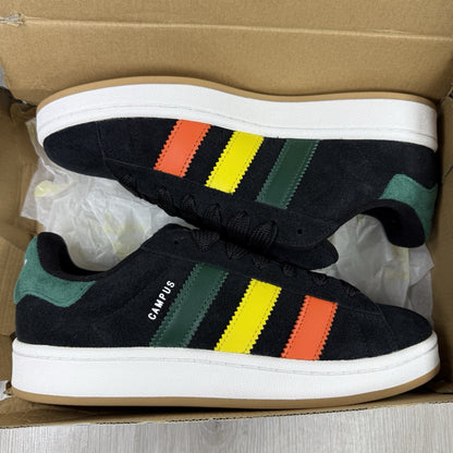 Adidas black trainers with yellow accents and classic three-stripe logo design.