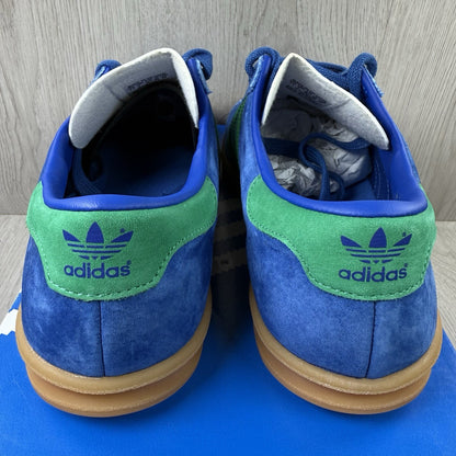 Adidas blue trainers with gum sole and iconic three-stripe logo design.