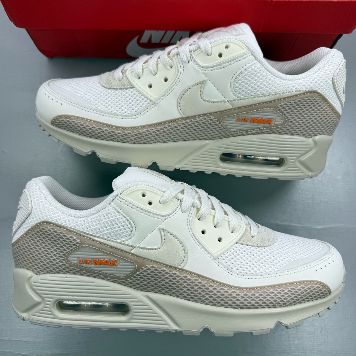 Nike Air Max 90 beige trainers with premium material and iconic logo detail.