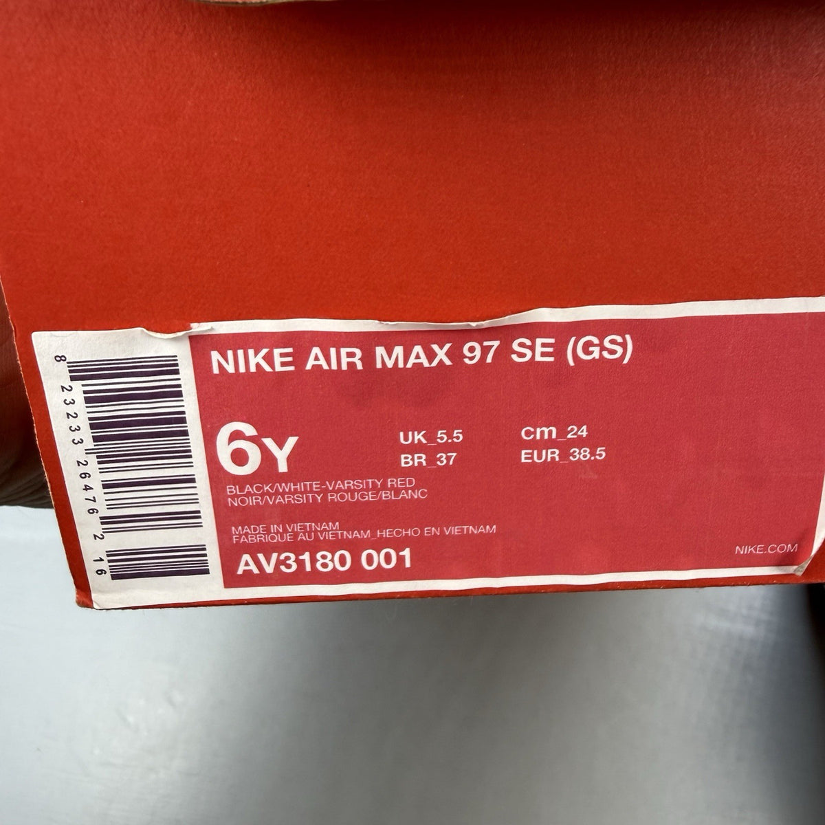 Nike Air Max 97 SE black trainers with white and varsity red accents, mesh and leather material.