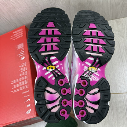 Nike Air Max Plus TN white trainers with fire pink foam fade and logo detailing.