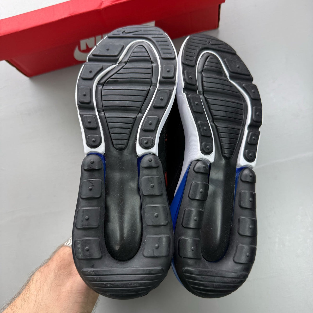 Nike black Air Max 270 trainers with blue accents and logo detail.