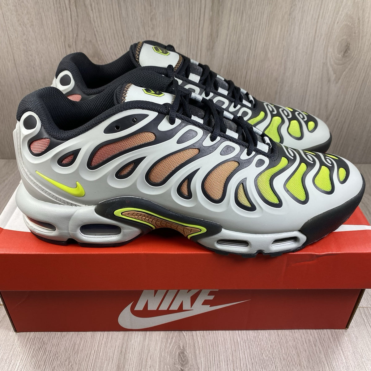 Nike Air Max Plus TN trainers silver with volt accents and signature logo details.