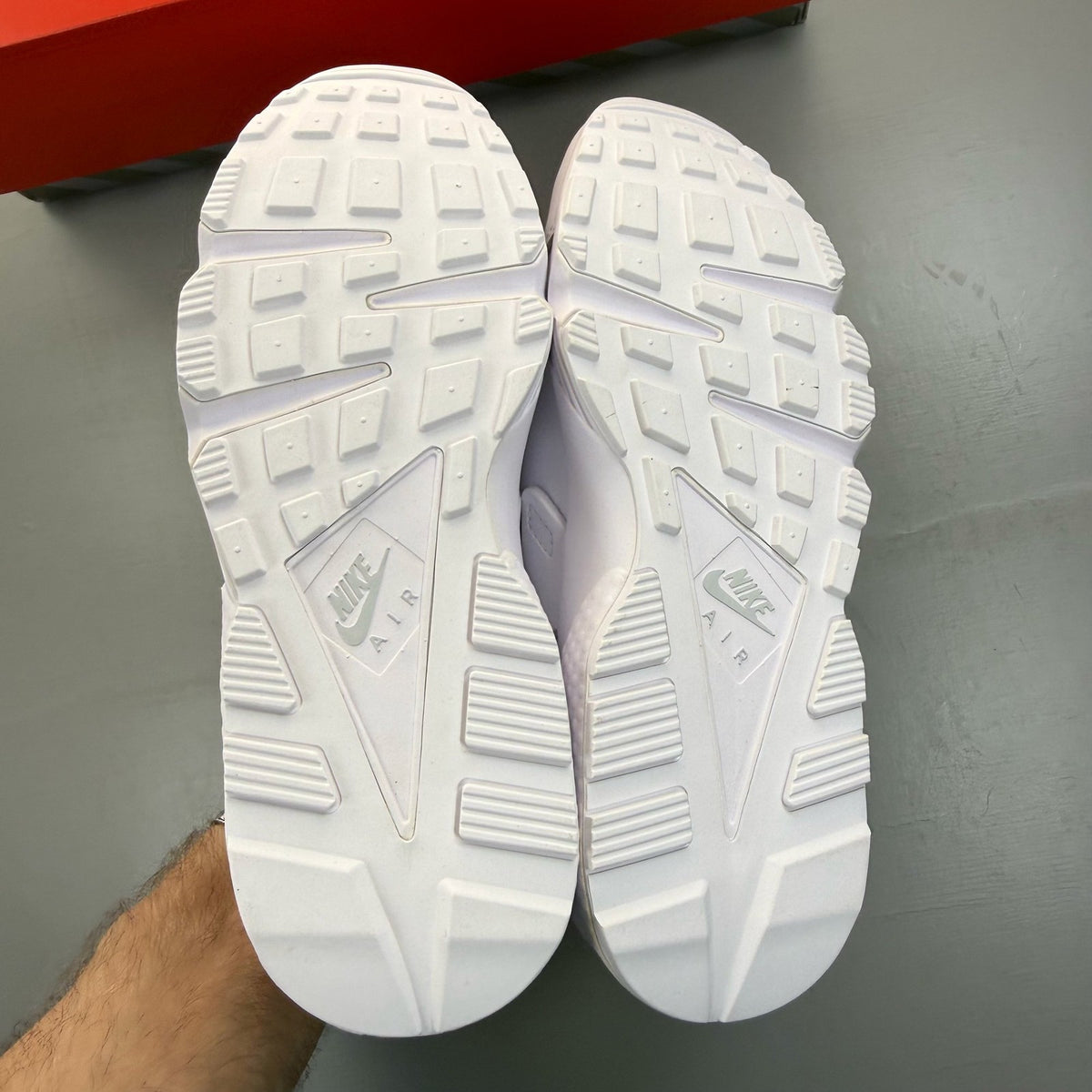 Nike Air Huarache white trainers with textured upper and signature logo detail.