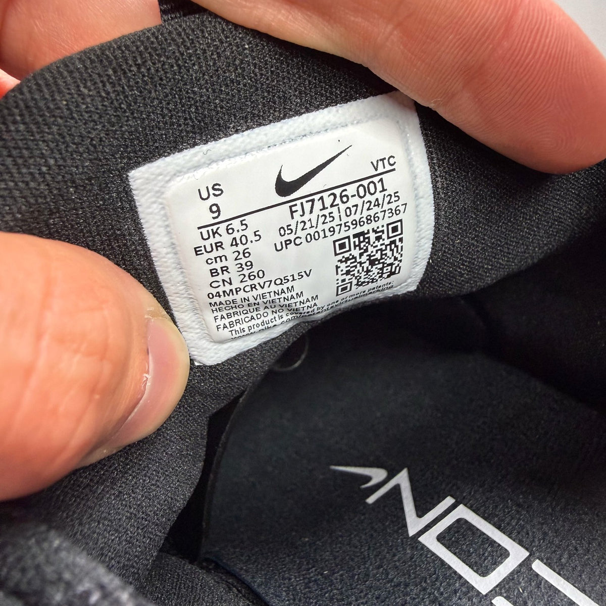 Nike black trainers with white accents and breathable mesh upper.