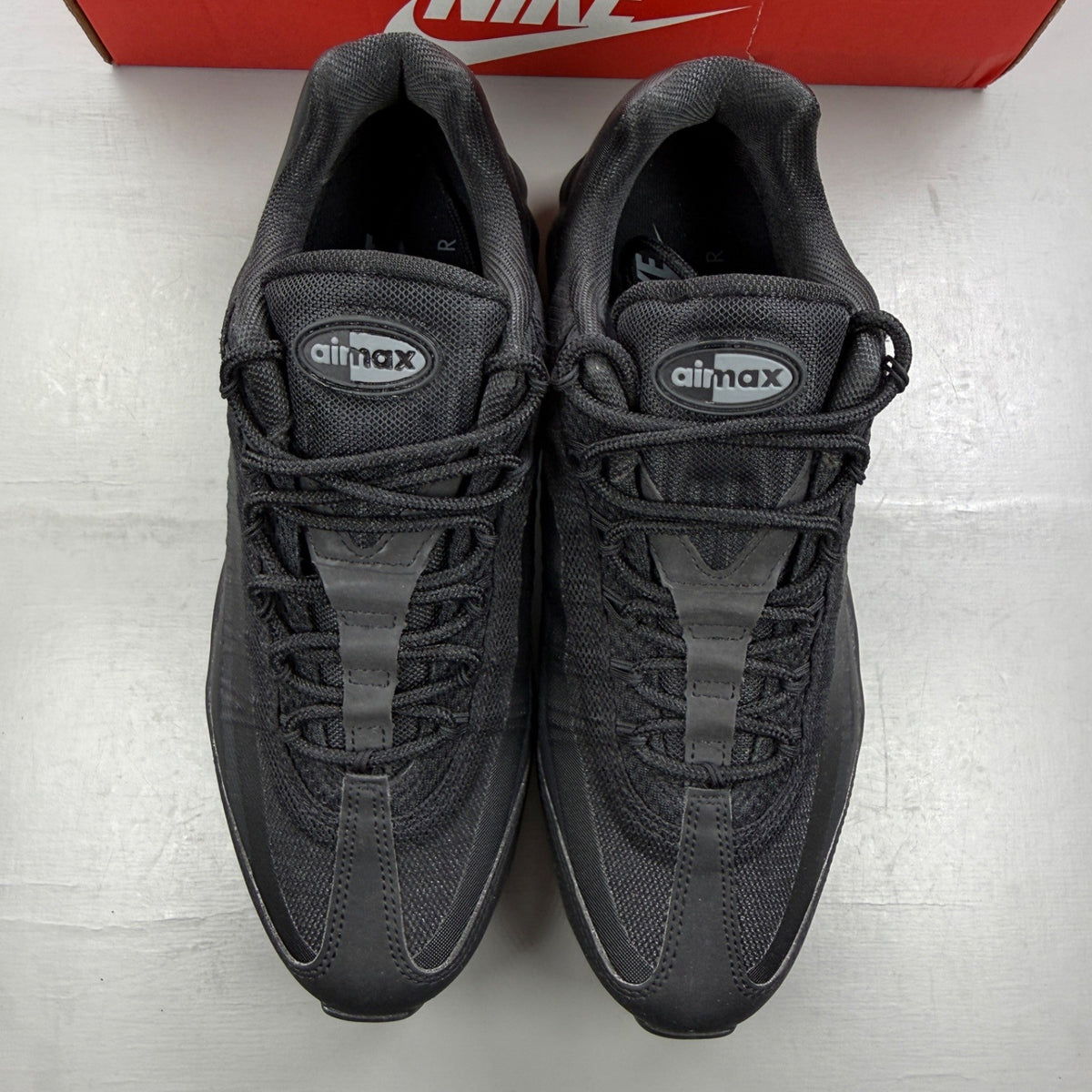 Nike Air Max 95 black trainers with grey accents and textured material.