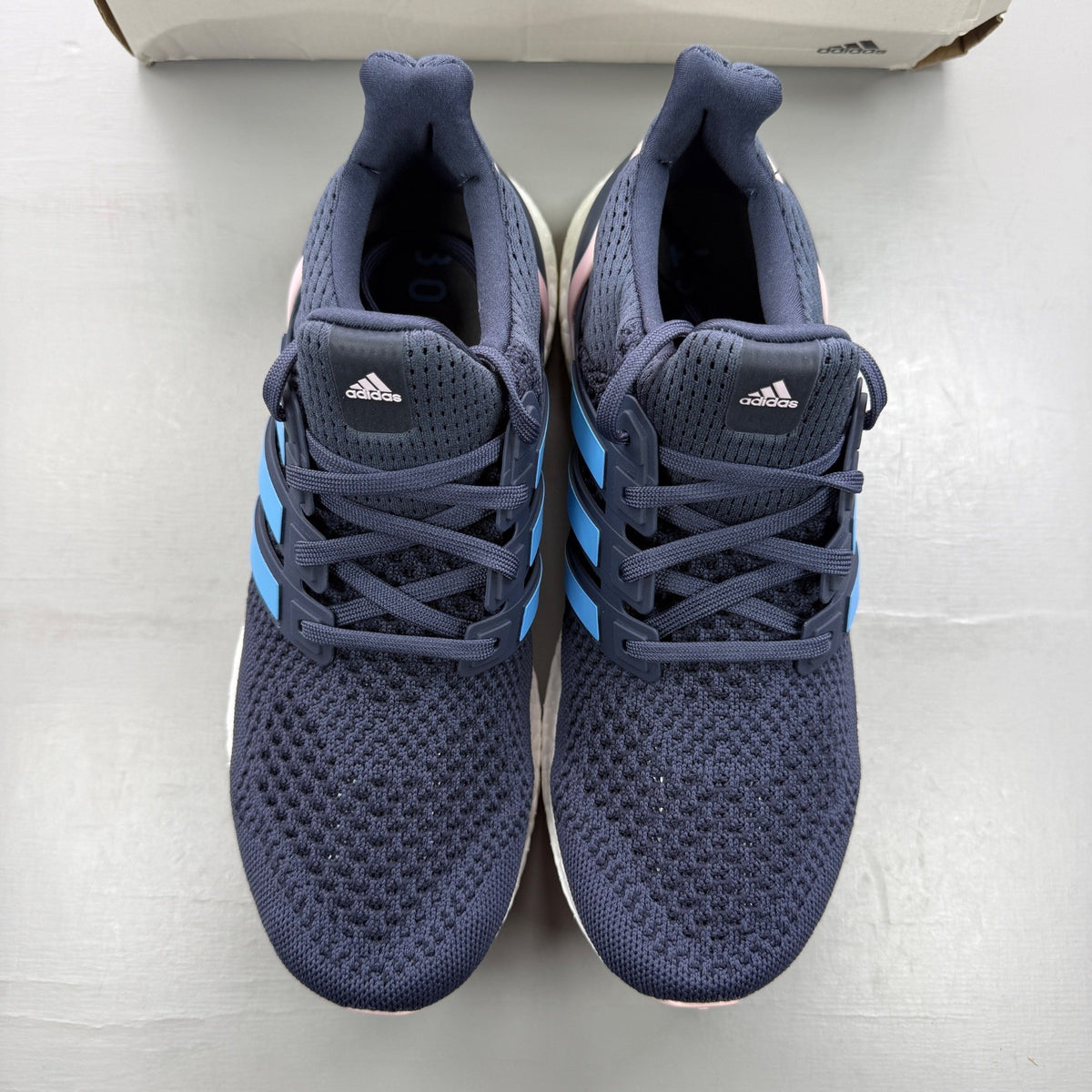 Adidas blue trainers with mesh upper and signature three stripes logo.