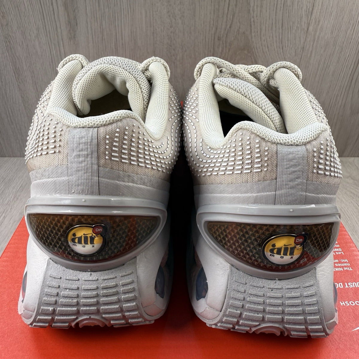 Nike Air Max DN trainers white with light brown accents and logo detail.