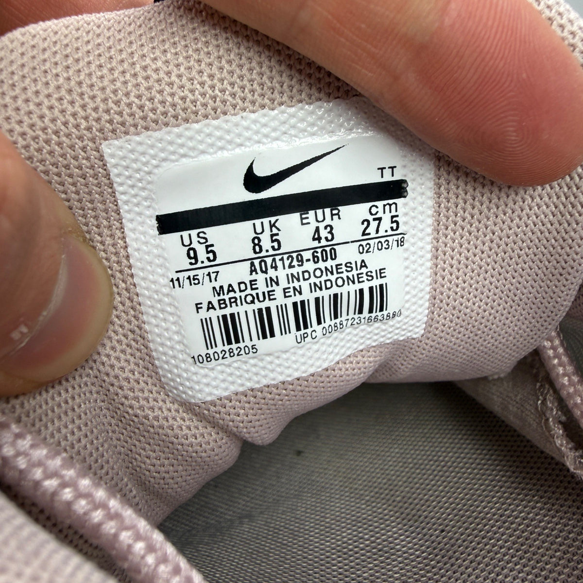 Nike trainers pink with white accents and Air Max cushioning details.