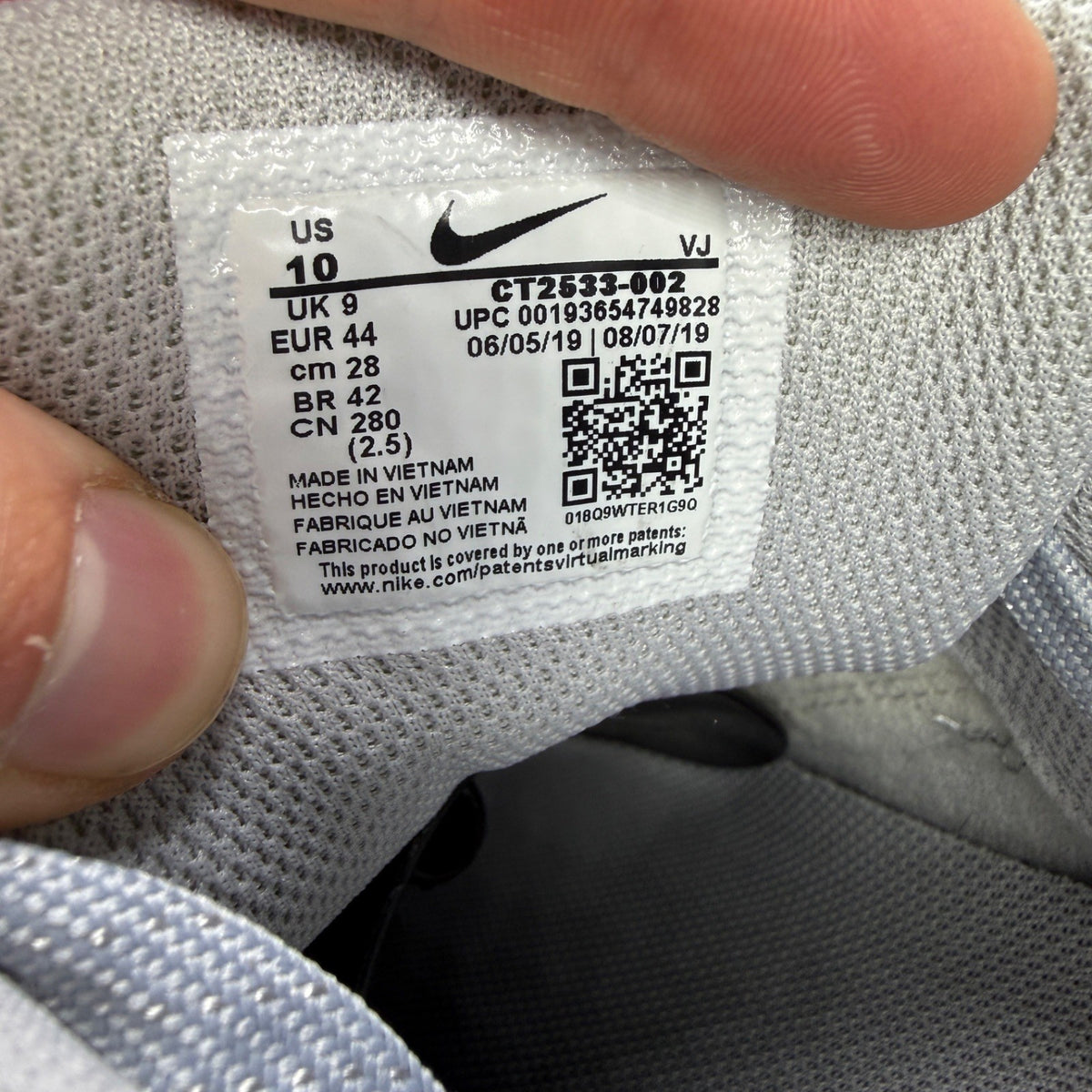 Nike running shoes grey mesh upper with white accents and signature swoosh logo.