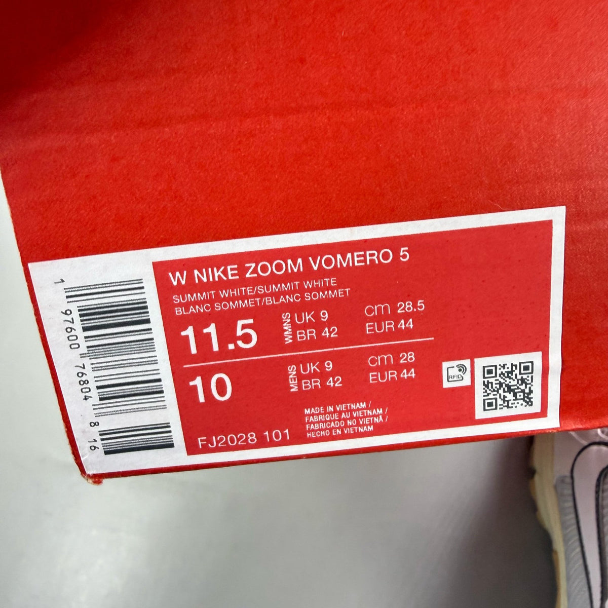 Nike Zoom Vomero 5 white trainers with grey accents and logo detailing.