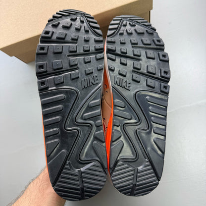 Nike black trainers with camo pattern and orange accents, featuring premium materials.