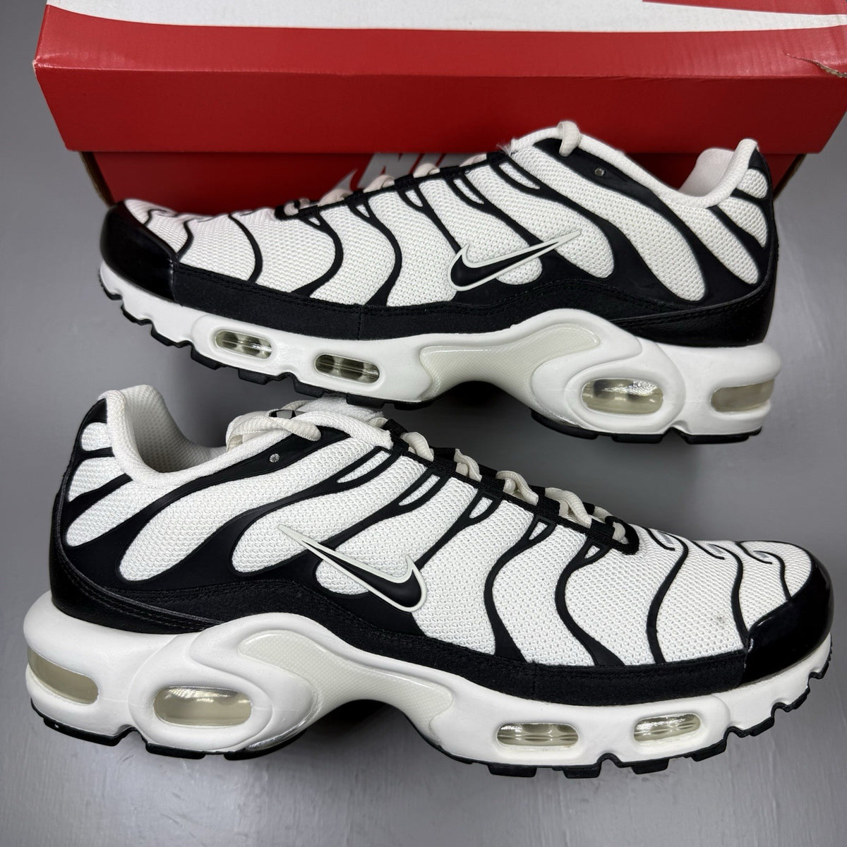 Nike Air Max Plus TN trainers white with black accents and signature logo details.