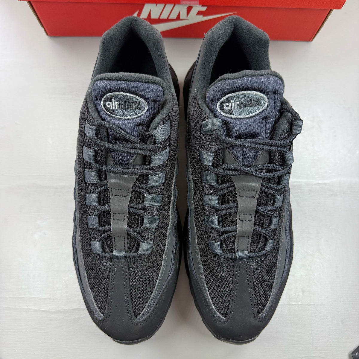 Nike black trainers with grey accents and signature swoosh logo, size UK 9.5.