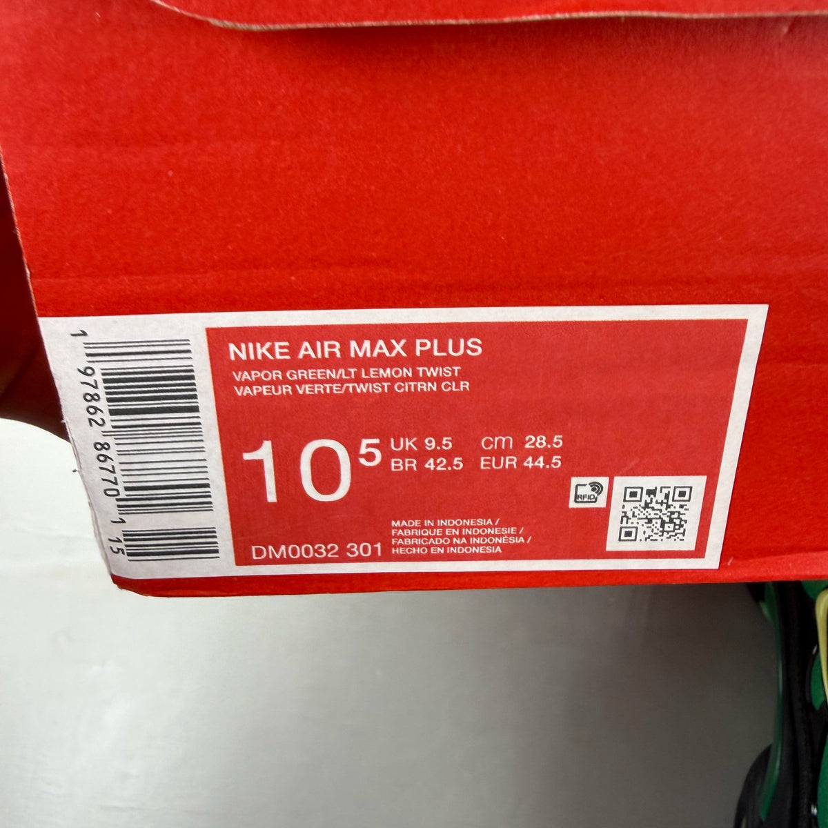 Nike Air Max Plus TN green trainers with lemon twist accents and signature logo.