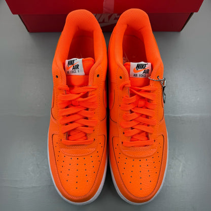 Nike Air Force 1 Low orange trainers with 'Just Do It' logo and sleek design.
