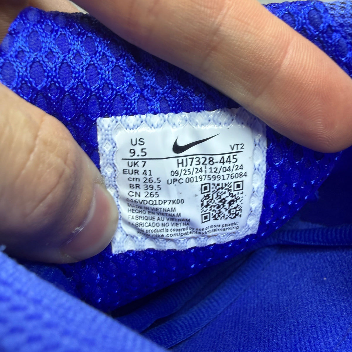 Nike Zoom Vomero 5 blue trainers with silver accents and logo detailing.