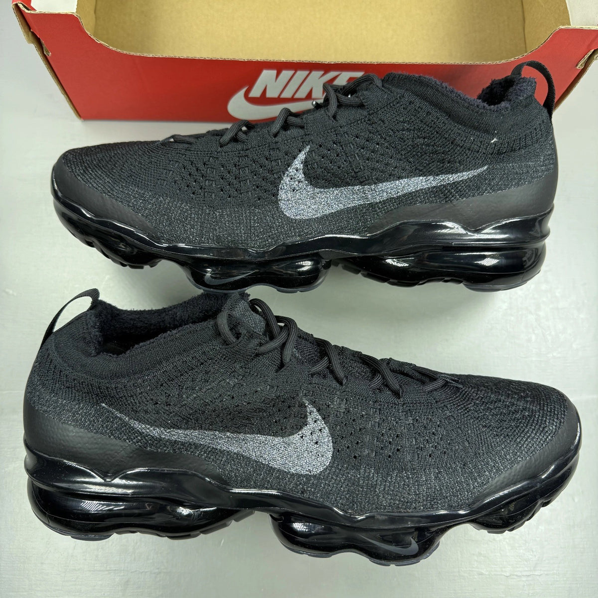Nike Air VaporMax 2023 black Flyknit sneakers with visible logo and sleek design.
