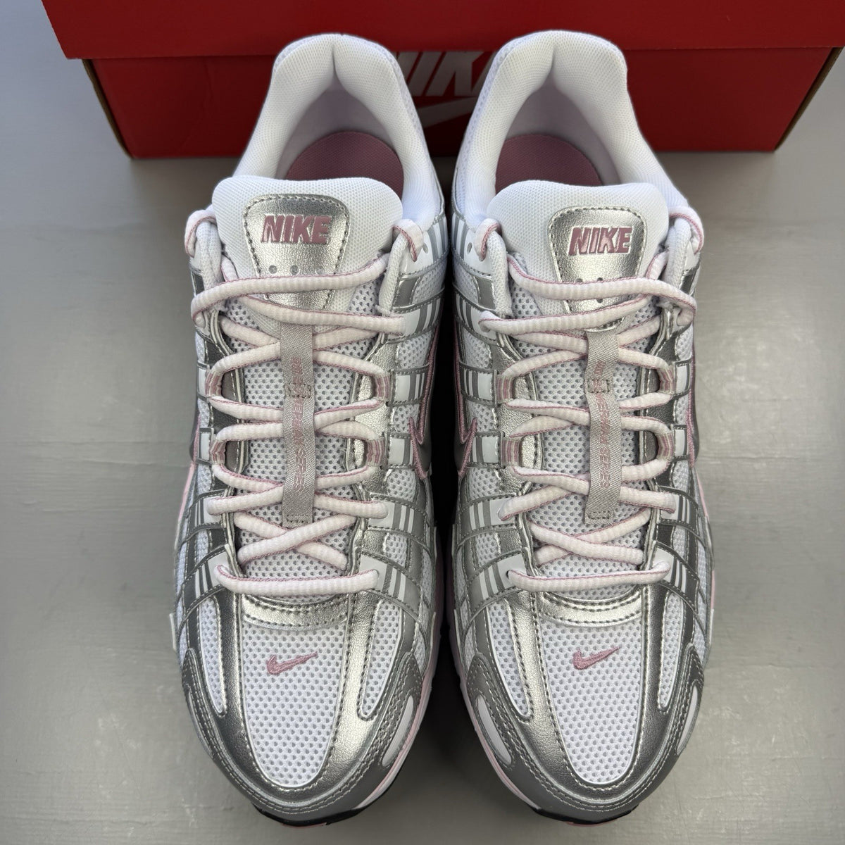 Nike P-6000 white trainers with elemental pink and silver accents, featuring logo details.