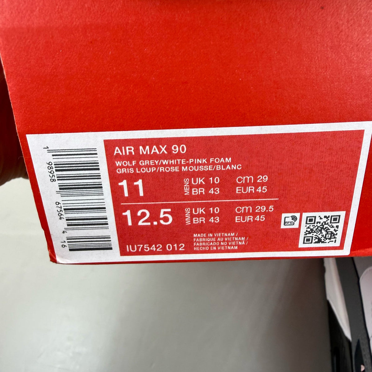 Nike Air Max 90 grey trainers with pink foam accents and white sole.