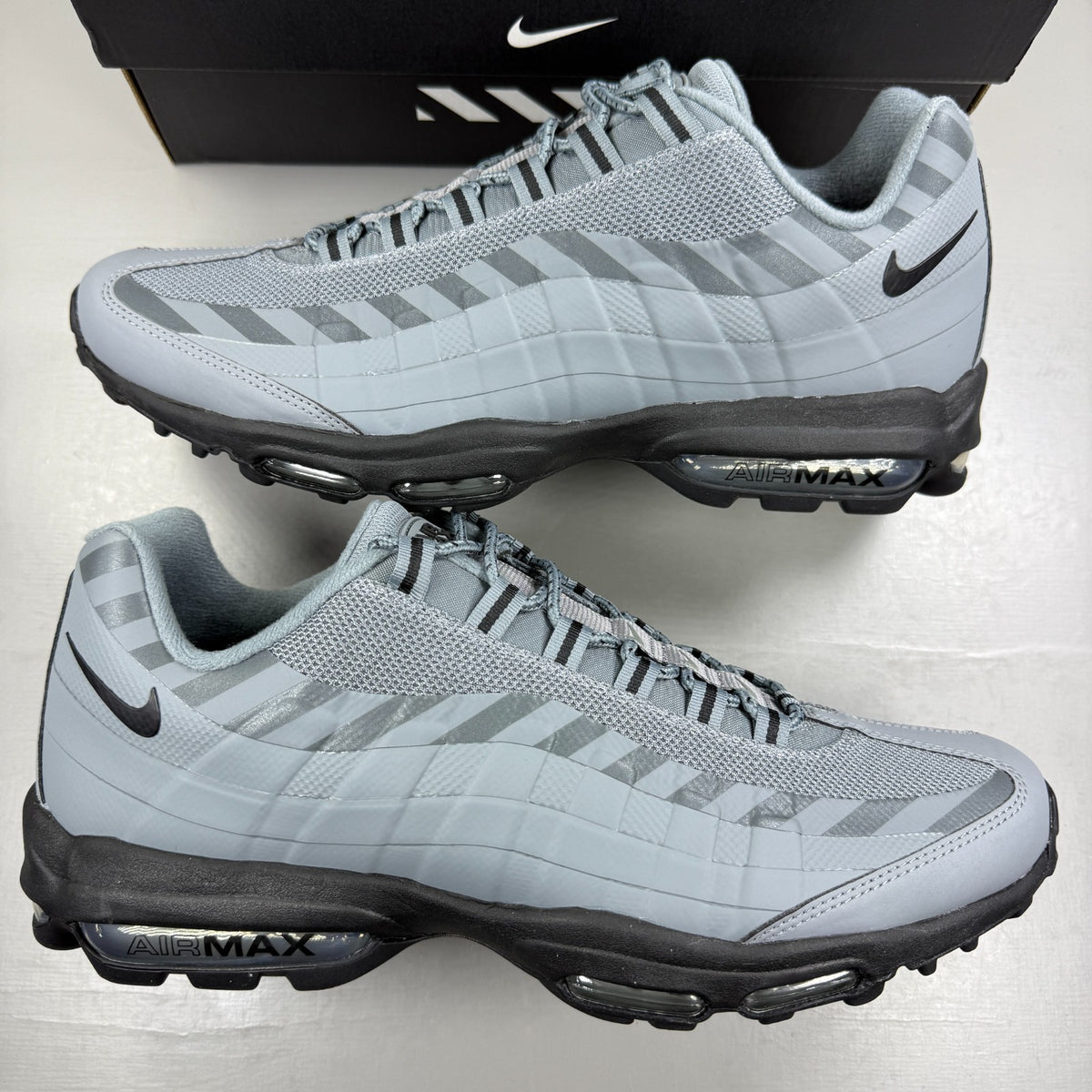 Nike running shoes grey with caution strip detailing and Air Max cushioning.