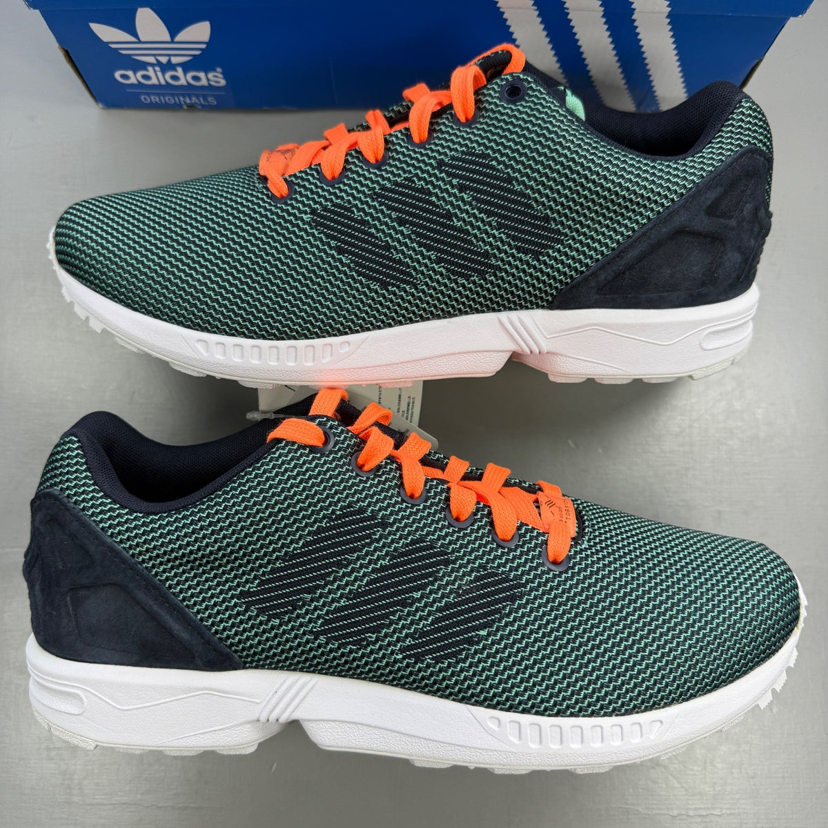 Adidas ZX Flux green trainers with woven texture and night navy accents.