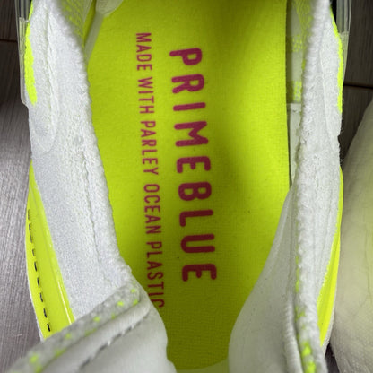 Adidas Ultra Boost 21 white trainers with solar yellow accents and signature three-stripe logo.