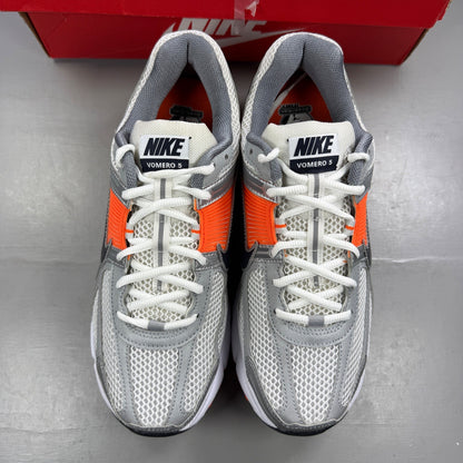 Nike running shoes orange with grey accents and distinctive logo detailing.