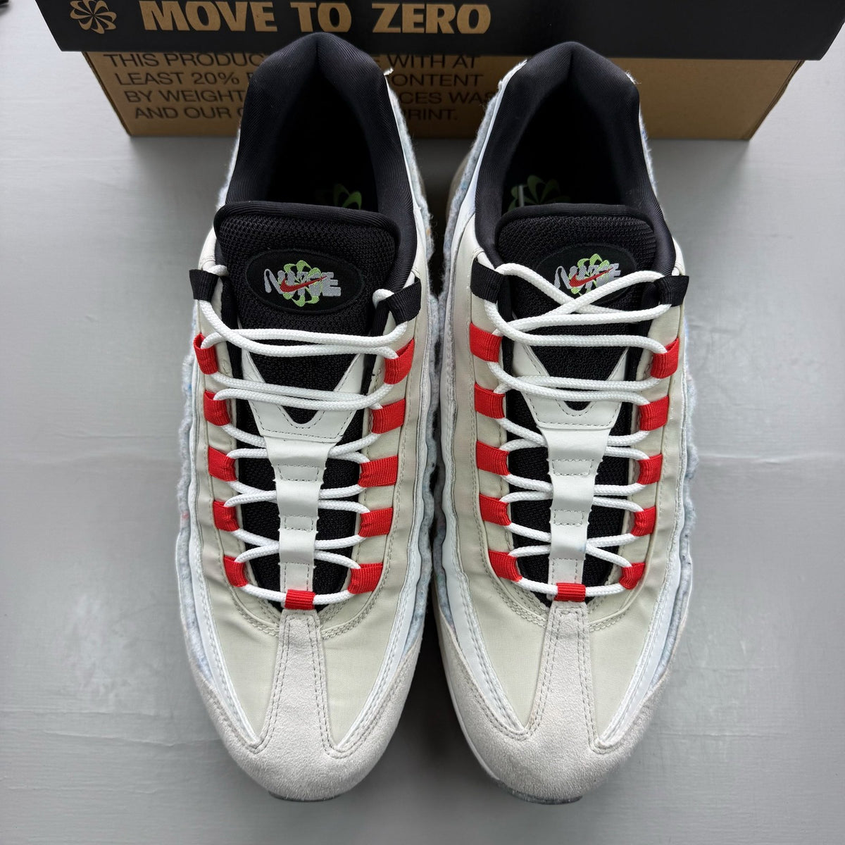 Nike Air Max 95 white trainers with red accents and textured mesh upper.