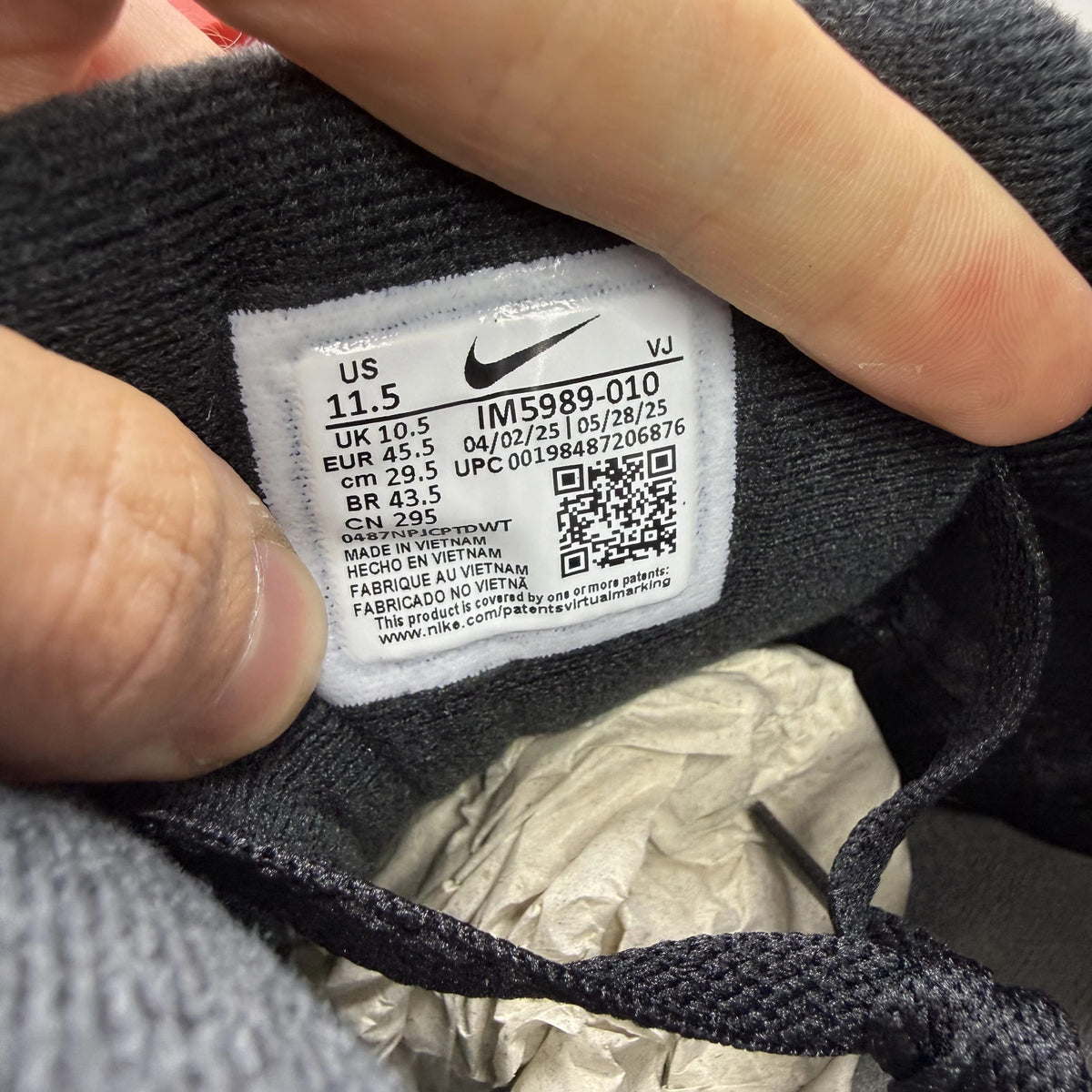 Nike Air Max 90 black trainers with smoke grey accents and logo detail.