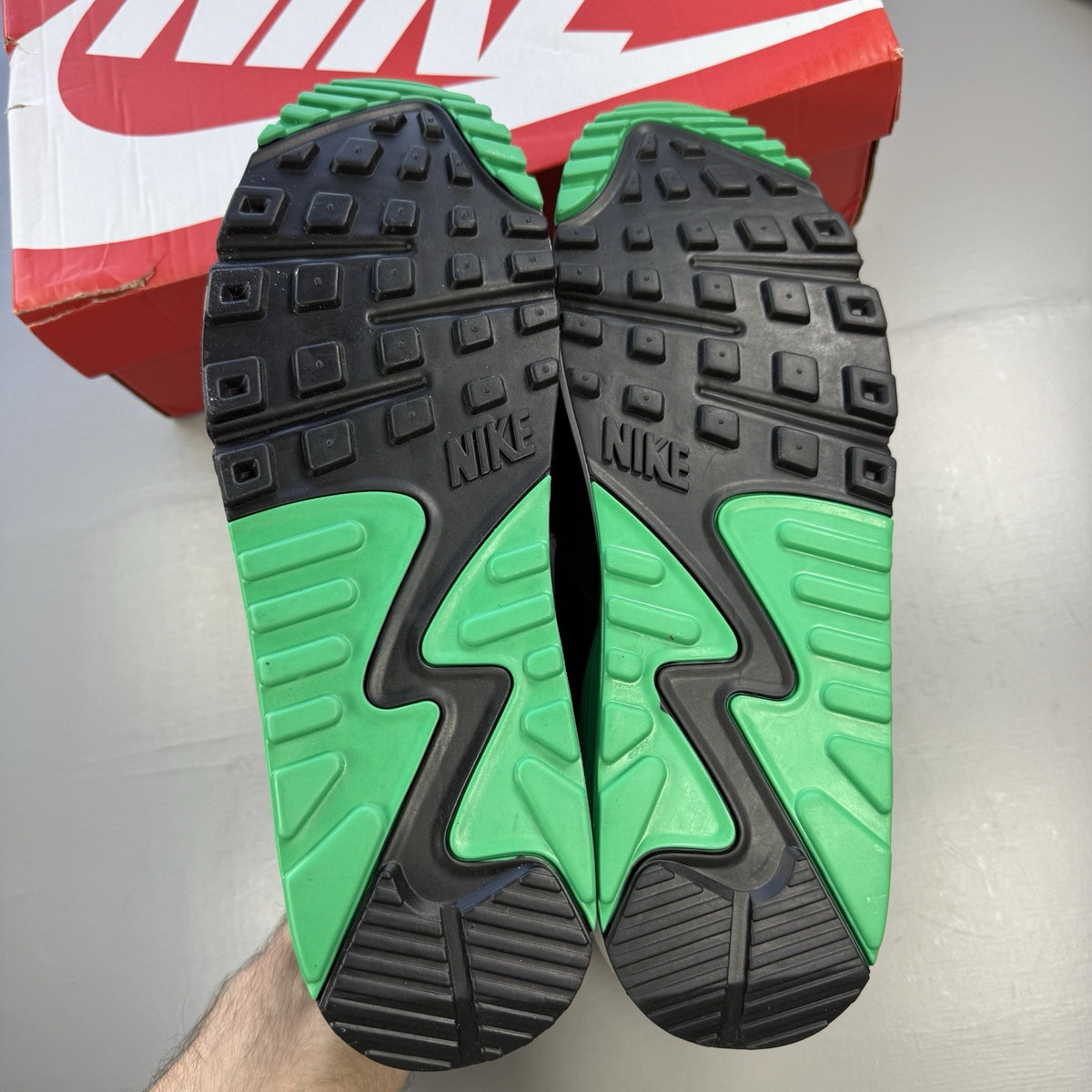 Nike Air Max 90 black trainers with stadium green accents and white sole.