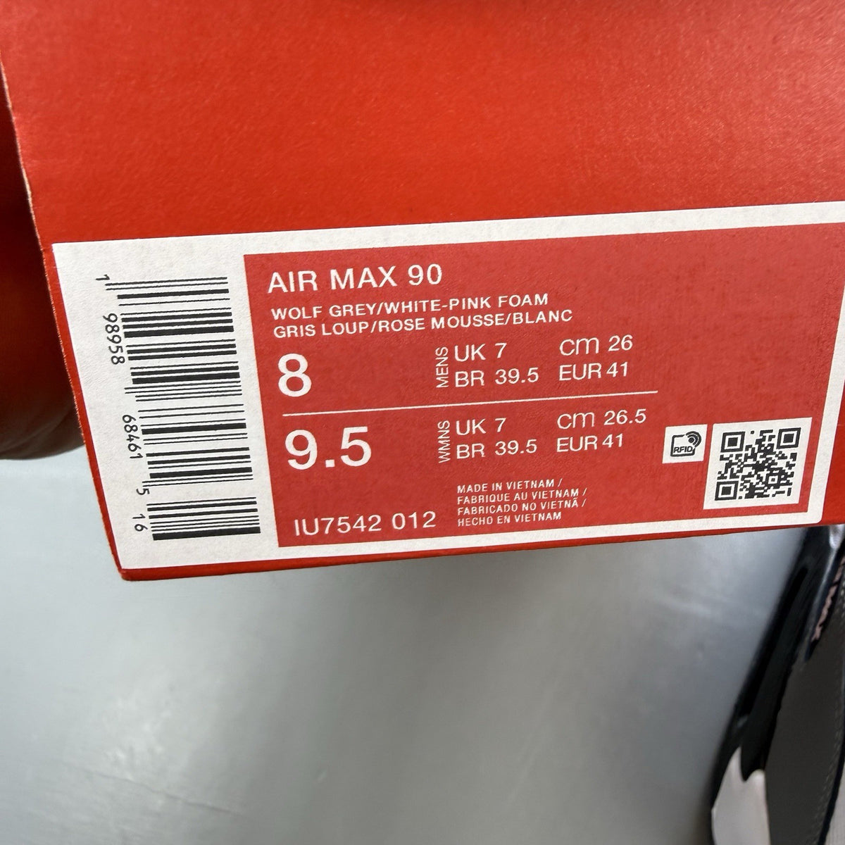 Nike Air Max 90 white trainers with pink foam accents and grey detailing.