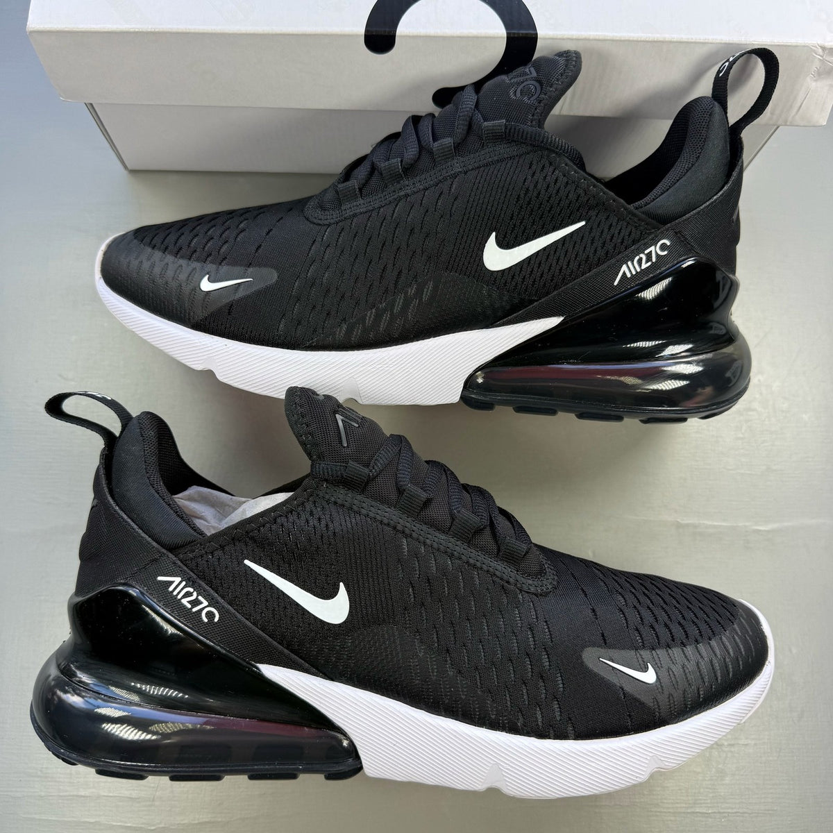 Nike black Air Max 270 trainers with white accents and logo detail.