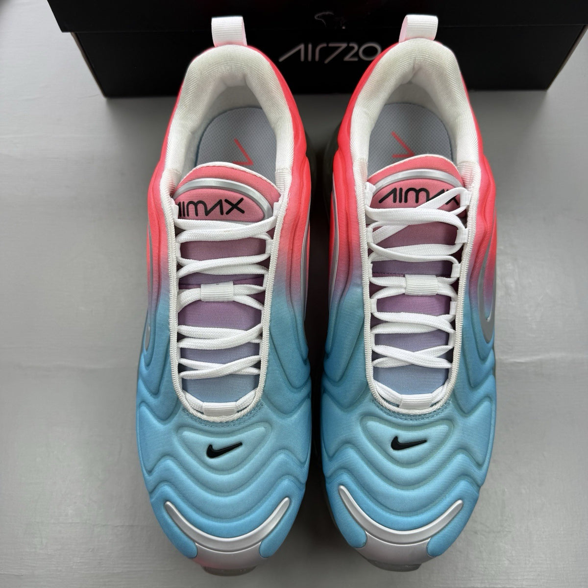 Nike Air Max 720 trainers blue with pink and lava glow accents, mesh upper.