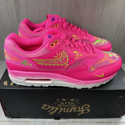Nike Air Max 1 PRM trainers pink with Día De Muertos pattern and white accents.