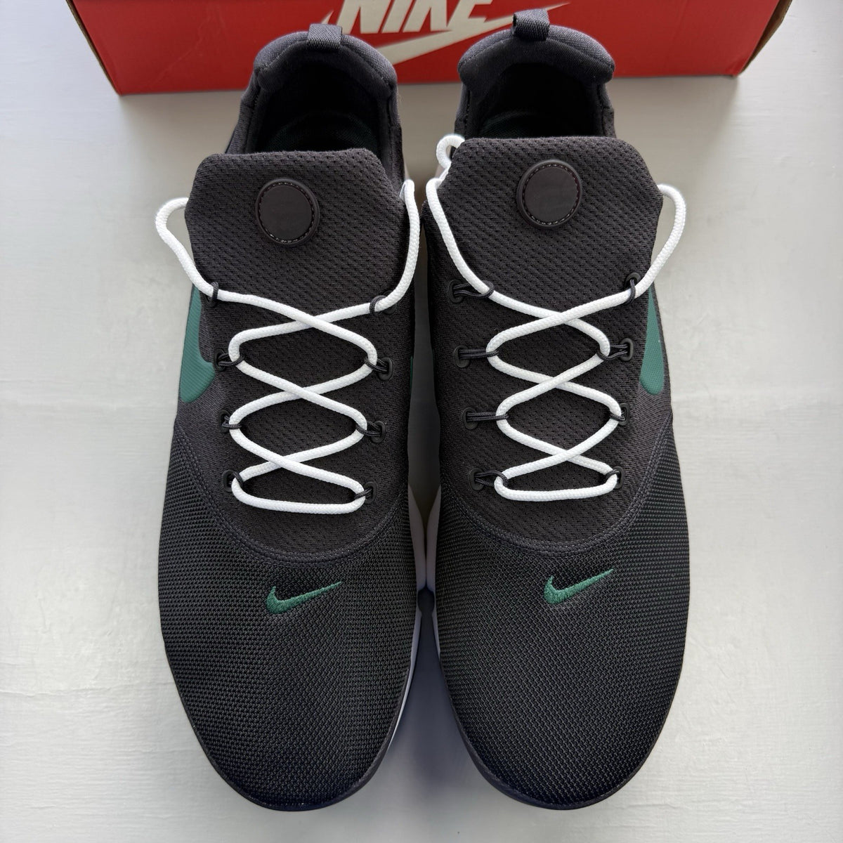 Nike Presto Fly black trainers with grey accents and white sole, featuring logo details.