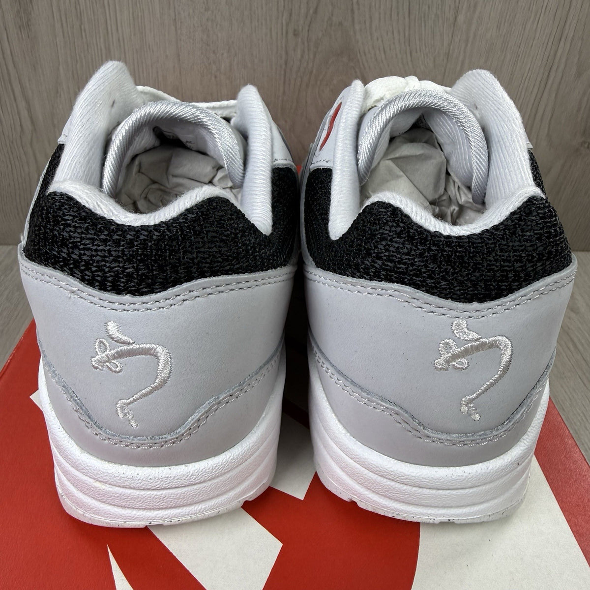 Nike Air Max 1 trainers grey with white accents and signature swoosh logo.