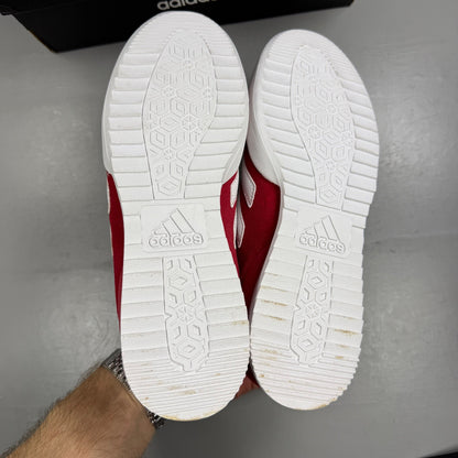 Adidas red suede running trainers with white logo and classic design details.